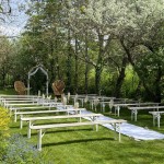 Espace de cérémonie de mariage avec des bancs et une allée en tissu blanc