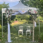 Chaises des mariés sous une tonnelle décorée