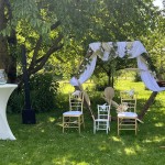Les chaises des mariés sous un portique, sous un cerisier
