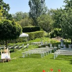 Une zone de cérémonie de mariage dans le parc avec des bancs et une tonnelle
