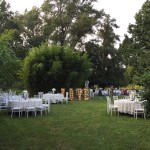 Garden party sous les arbres avec tables blanches et décorations
