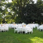ensembles de tables et de chaises blanches pour une réception dans un jardin, sous des arbres