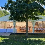 Un chapiteau avec des tables décorées dans le jardin
